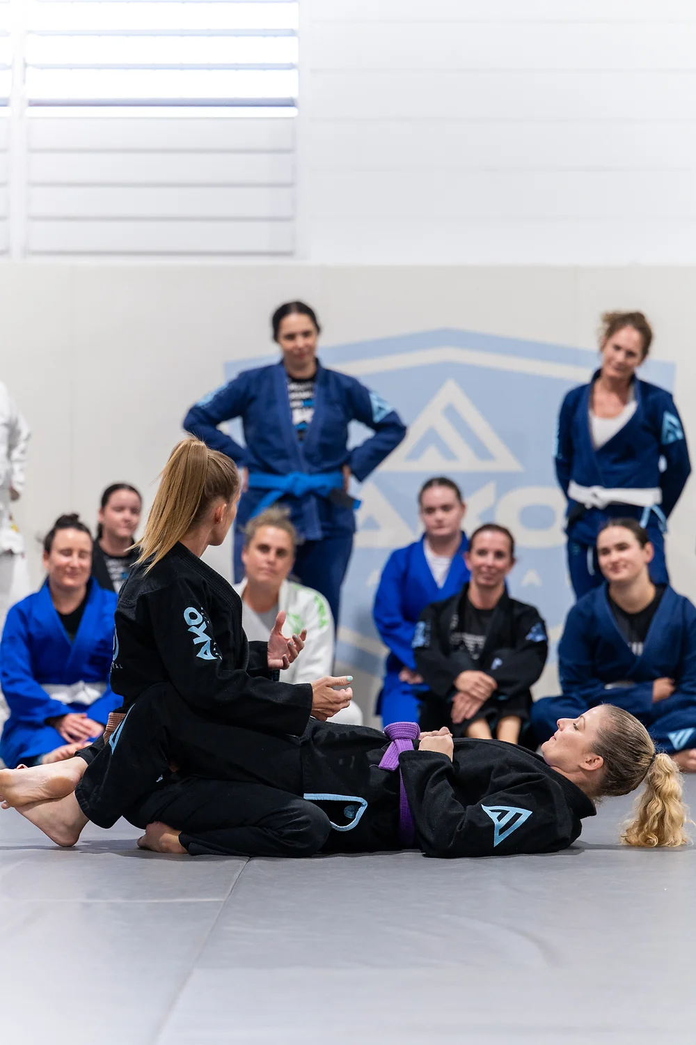 Linzi teaching a women's class at Ako Martial Arts — demonstrating a technique while the group watches