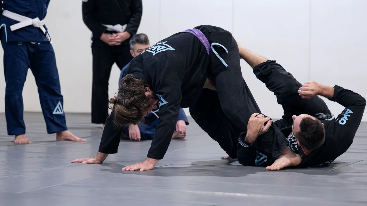 An adult student working from a bad position while a coach watches on at Ako Martial Arts
