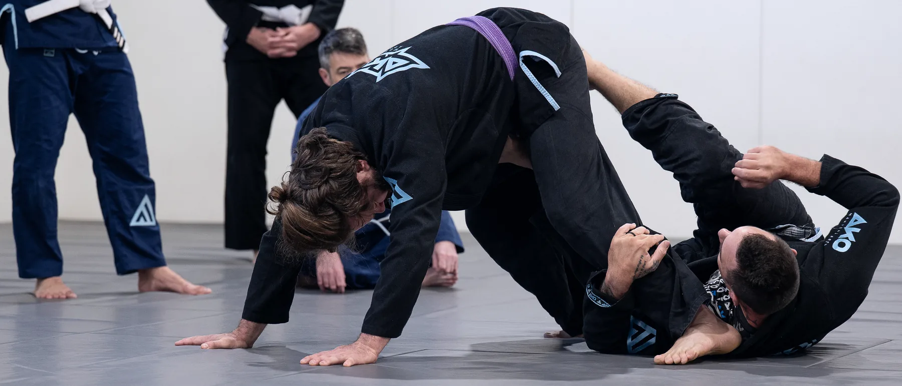 An adult student working from a bad position while a coach watches on at Ako Martial Arts